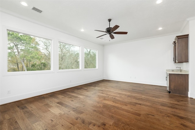 unfurnished room with sink, ornamental molding, dark hardwood / wood-style floors, and ceiling fan