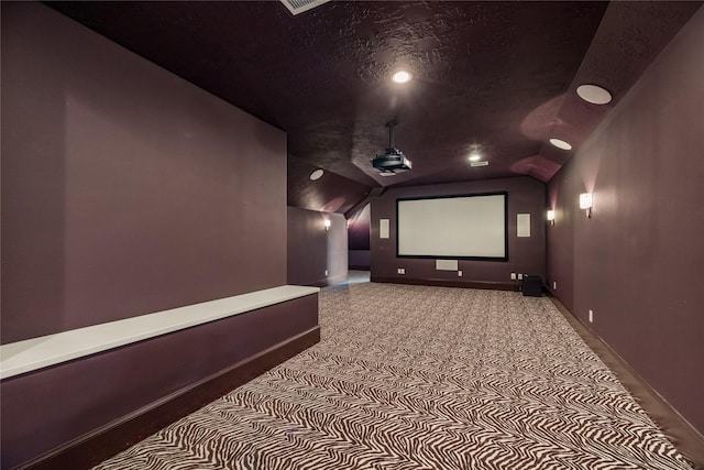 cinema room with lofted ceiling, baseboards, and a textured ceiling