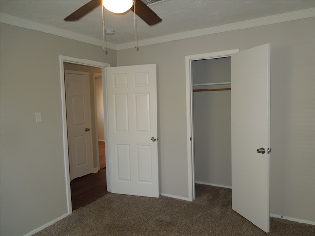 unfurnished bedroom featuring ceiling fan, crown molding, and dark carpet