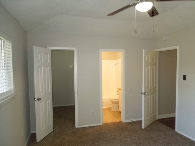 unfurnished bedroom featuring connected bathroom, lofted ceiling, ceiling fan, and carpet flooring