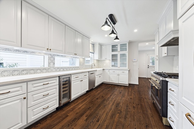 kitchen featuring appliances with stainless steel finishes, white cabinets, beverage cooler, and dark hardwood / wood-style flooring