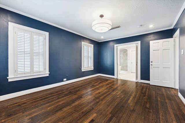 spare room with a textured ceiling, ornamental molding, and dark hardwood / wood-style flooring