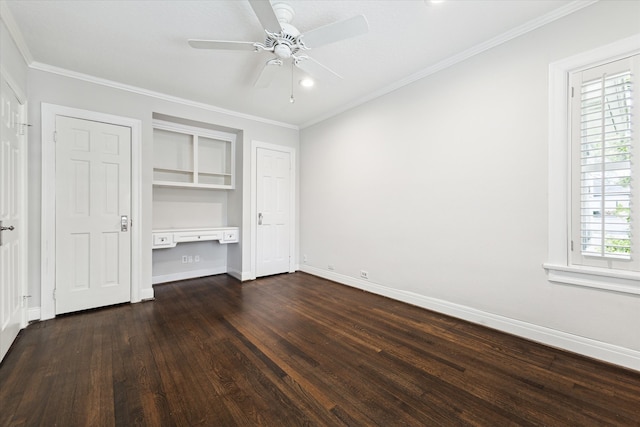 unfurnished bedroom with ornamental molding, built in desk, ceiling fan, and dark wood-type flooring