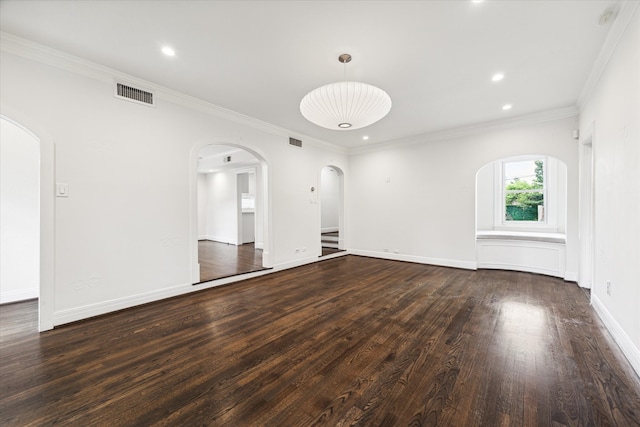 spare room with ornamental molding and dark wood-type flooring