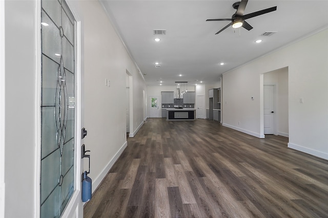 interior space with ceiling fan, crown molding, and dark wood-type flooring