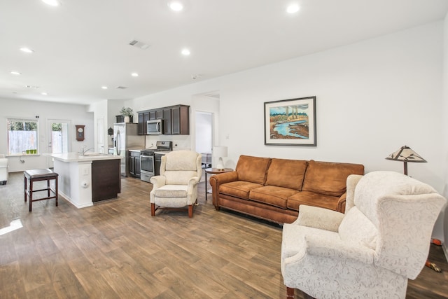 living room with dark hardwood / wood-style flooring and sink