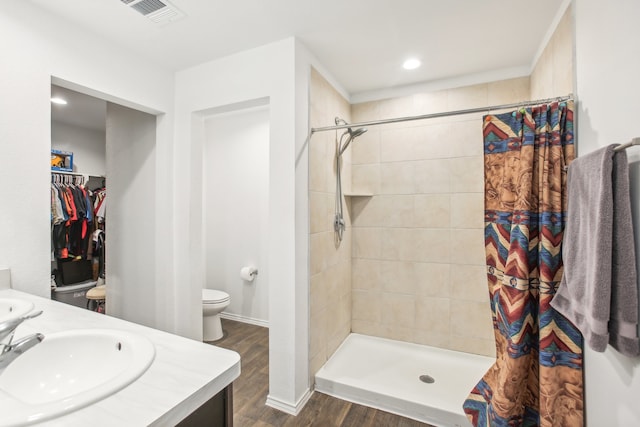 bathroom featuring curtained shower, wood-type flooring, vanity, and toilet