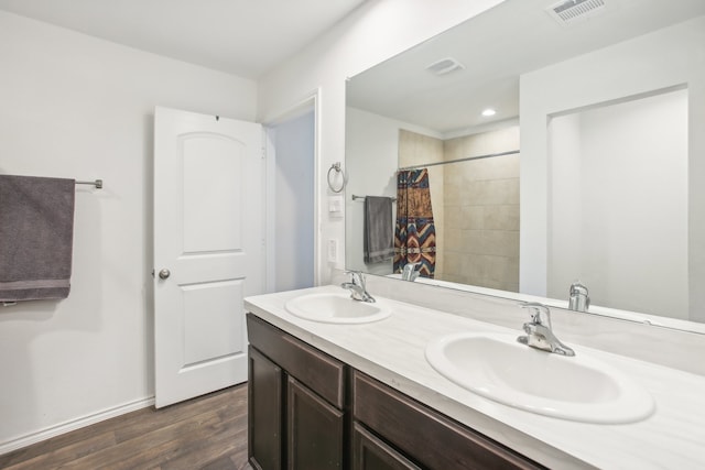 bathroom with walk in shower, vanity, and hardwood / wood-style flooring