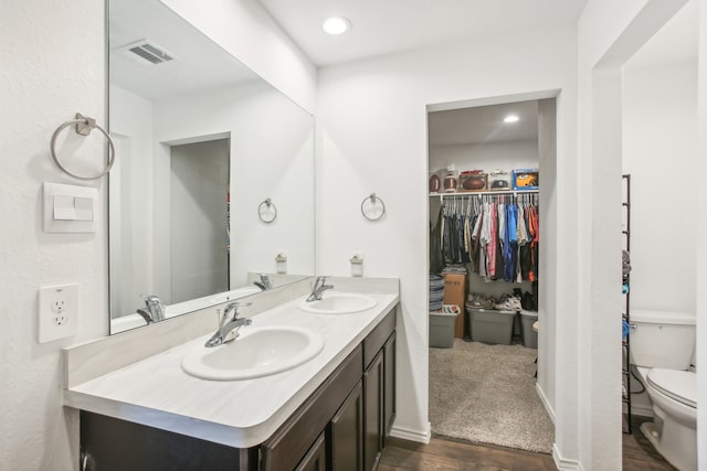 bathroom with wood-type flooring, vanity, and toilet