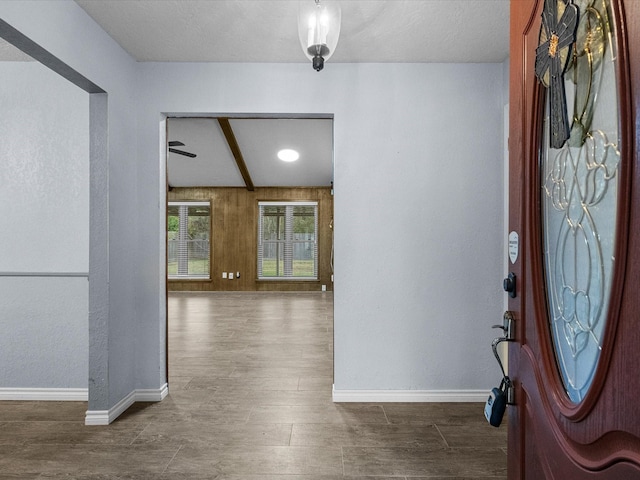 foyer entrance with hardwood / wood-style flooring, ceiling fan, and beam ceiling