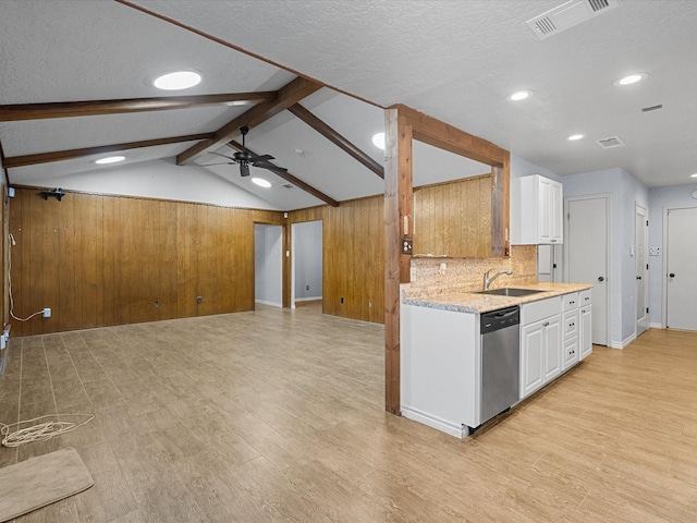 kitchen featuring stainless steel dishwasher, ceiling fan, light hardwood / wood-style flooring, white cabinets, and wood walls