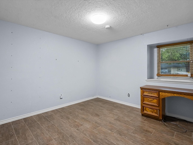 spare room with wood-type flooring and a textured ceiling