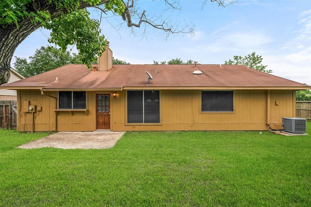 back of property featuring central AC unit and a lawn