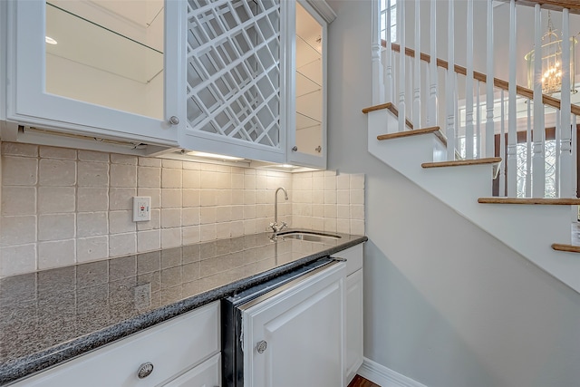 kitchen with backsplash, white cabinetry, plenty of natural light, and sink