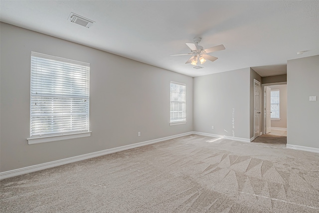 carpeted spare room featuring ceiling fan