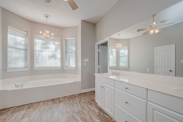 bathroom with vanity, a healthy amount of sunlight, wood-type flooring, and a tub