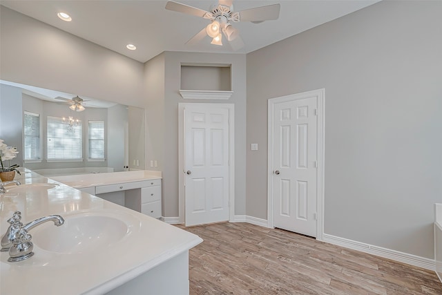 bathroom featuring vanity, ceiling fan, wood-type flooring, and a bath