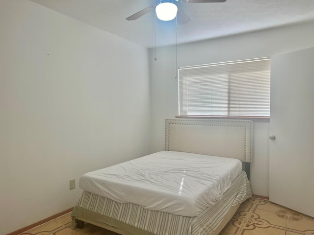 tiled bedroom featuring ceiling fan