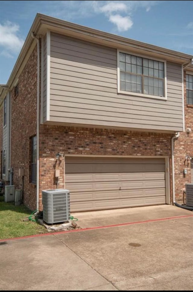 view of home's exterior featuring a garage and cooling unit