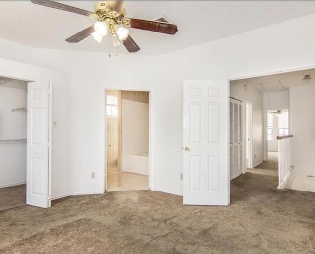 unfurnished bedroom featuring carpet flooring, ensuite bathroom, and ceiling fan