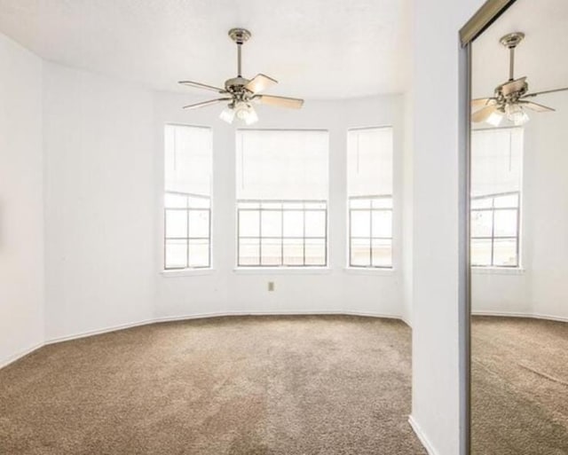 carpeted empty room featuring ceiling fan