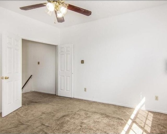 carpeted spare room with ceiling fan