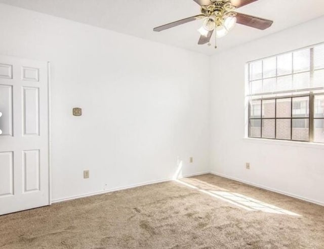 carpeted spare room with ceiling fan