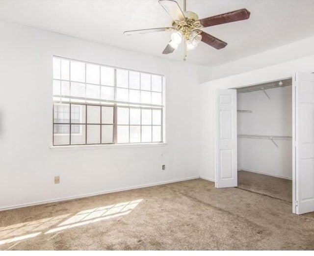 unfurnished bedroom featuring ceiling fan, a closet, and carpet