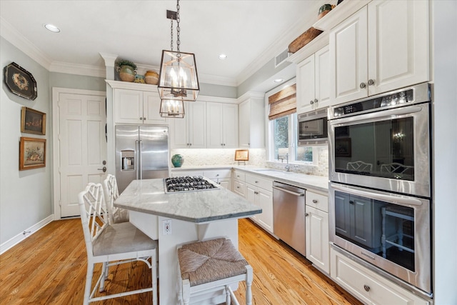 kitchen with a kitchen island, white cabinetry, stainless steel appliances, and a kitchen breakfast bar