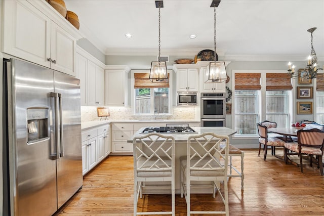 kitchen with appliances with stainless steel finishes, light wood-type flooring, white cabinetry, and backsplash