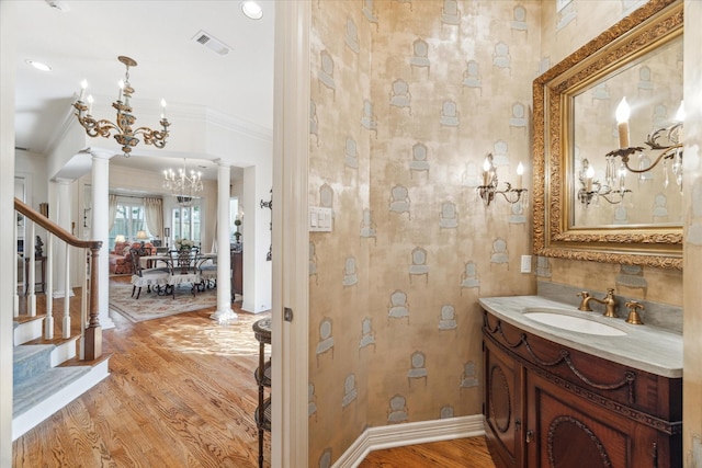 bathroom with crown molding, decorative columns, visible vents, an inviting chandelier, and wood finished floors