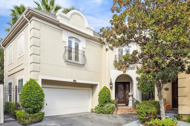 mediterranean / spanish house featuring an attached garage, driveway, and stucco siding