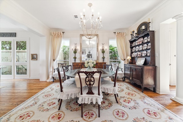 dining room featuring an inviting chandelier, visible vents, ornamental molding, and ornate columns