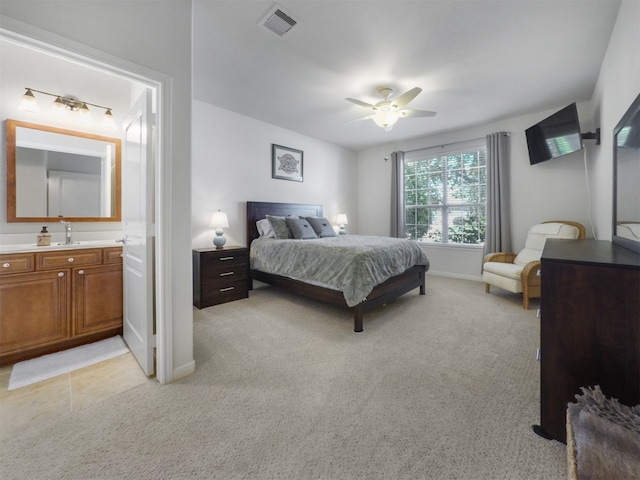 carpeted bedroom featuring ensuite bath, ceiling fan, and sink