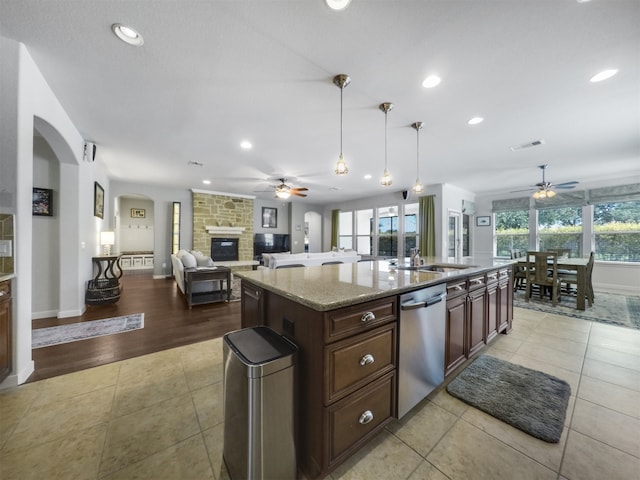 kitchen with light hardwood / wood-style flooring, dishwasher, a kitchen island, and a wealth of natural light