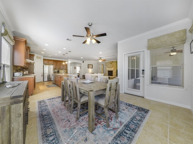 tiled dining area with a brick fireplace and ornamental molding