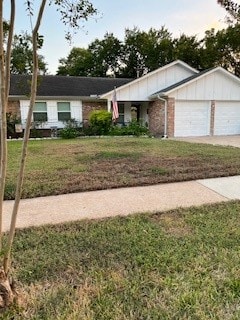 single story home featuring a front lawn and a garage