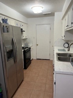 kitchen with white cabinets, sink, a textured ceiling, stainless steel fridge with ice dispenser, and electric range