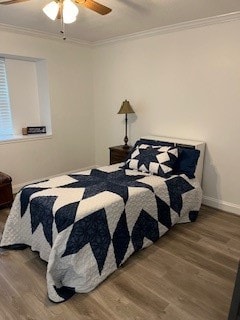 bedroom featuring ceiling fan, ornamental molding, and wood-type flooring