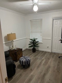 living area with ornamental molding and hardwood / wood-style floors