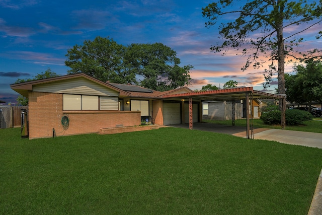 ranch-style home featuring a garage and a yard