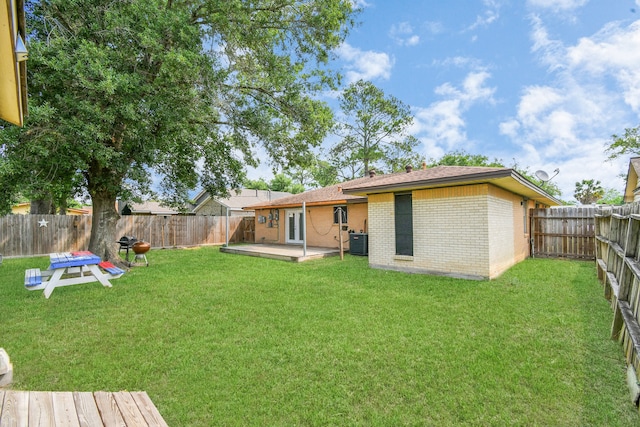 back of property with a patio, central air condition unit, and a yard