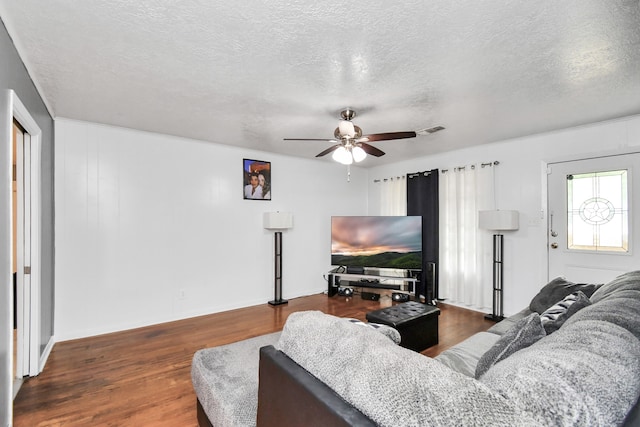 living room featuring a textured ceiling, dark hardwood / wood-style floors, and ceiling fan