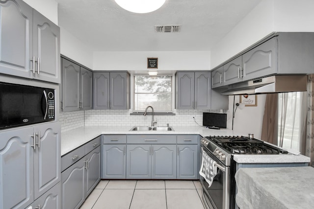 kitchen with gray cabinets, high end stove, and sink