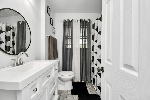 bathroom with vanity, hardwood / wood-style floors, toilet, and a textured ceiling