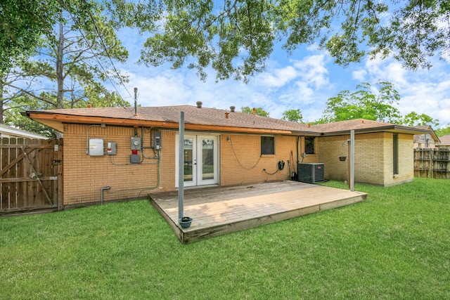 back of property featuring central AC unit, french doors, a deck, and a lawn