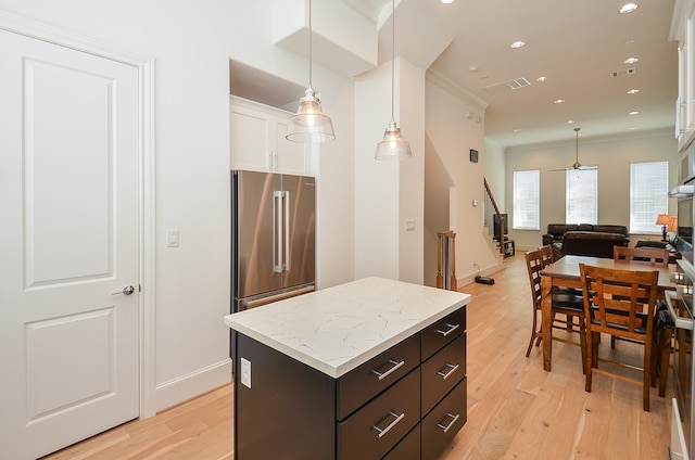 kitchen with high end fridge, crown molding, light hardwood / wood-style floors, and white cabinetry