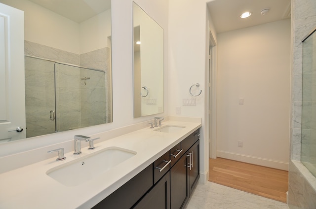 bathroom featuring walk in shower, hardwood / wood-style flooring, and vanity