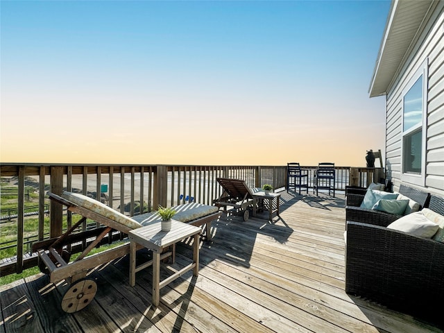 deck at dusk with an outdoor hangout area