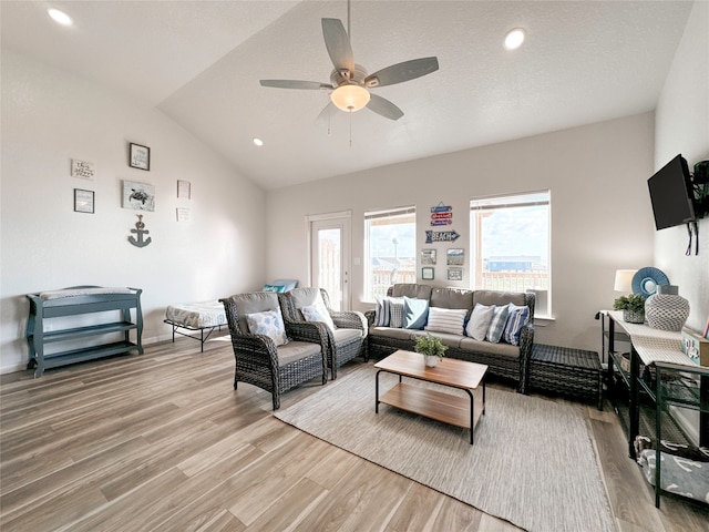 living room featuring vaulted ceiling, light hardwood / wood-style floors, and ceiling fan